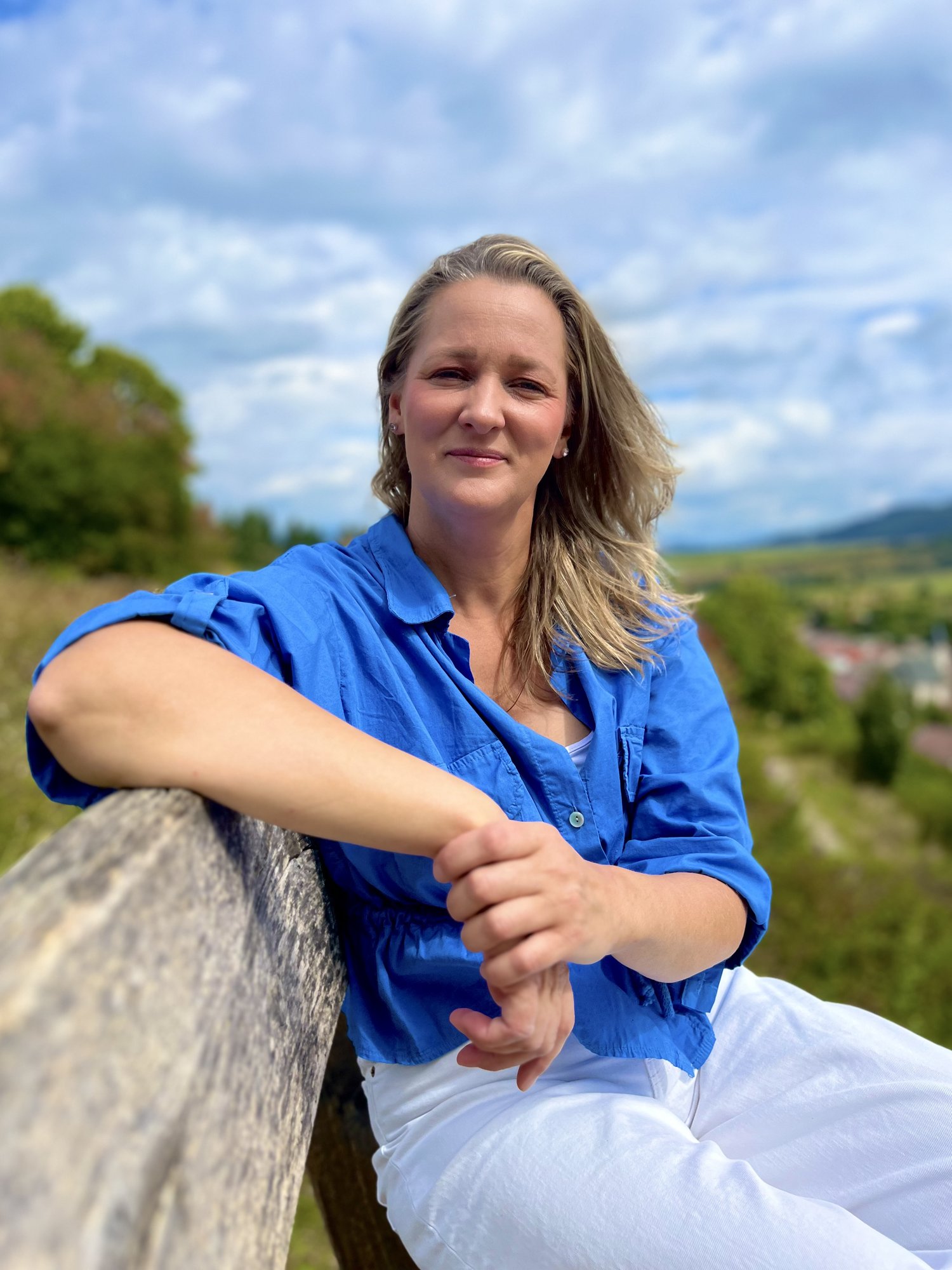 Zuzana Tomaníková pri drevenom plote s krajinou v pozadí